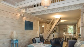 Ein gemütliches Blockhaus-Interieur mit Essbereich, einer Treppe und einer Küche.