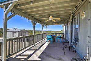 A covered porch with a ceiling fan, two blue chairs, and a table. - Quiet Tombstone Retreat ~ 3 Mi to Historic Dtwn! (Tombstone)