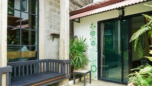 Eine Terrasse mit einer Bank, einem kleinen Tisch und Kübelpflanzen.