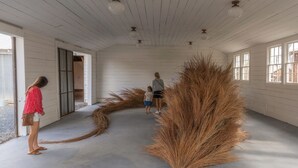 A room with white wooden walls, a concrete floor, and large windows. - “El Castellito” on the Llano River [4 Bed House] (Llano)