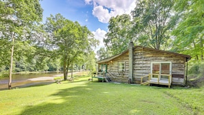 Une cabane rustique avec une façade en bois, une véranda et une petite terrasse.