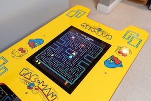 Una macchina arcade gialla con Pac-Man e altri personaggi.