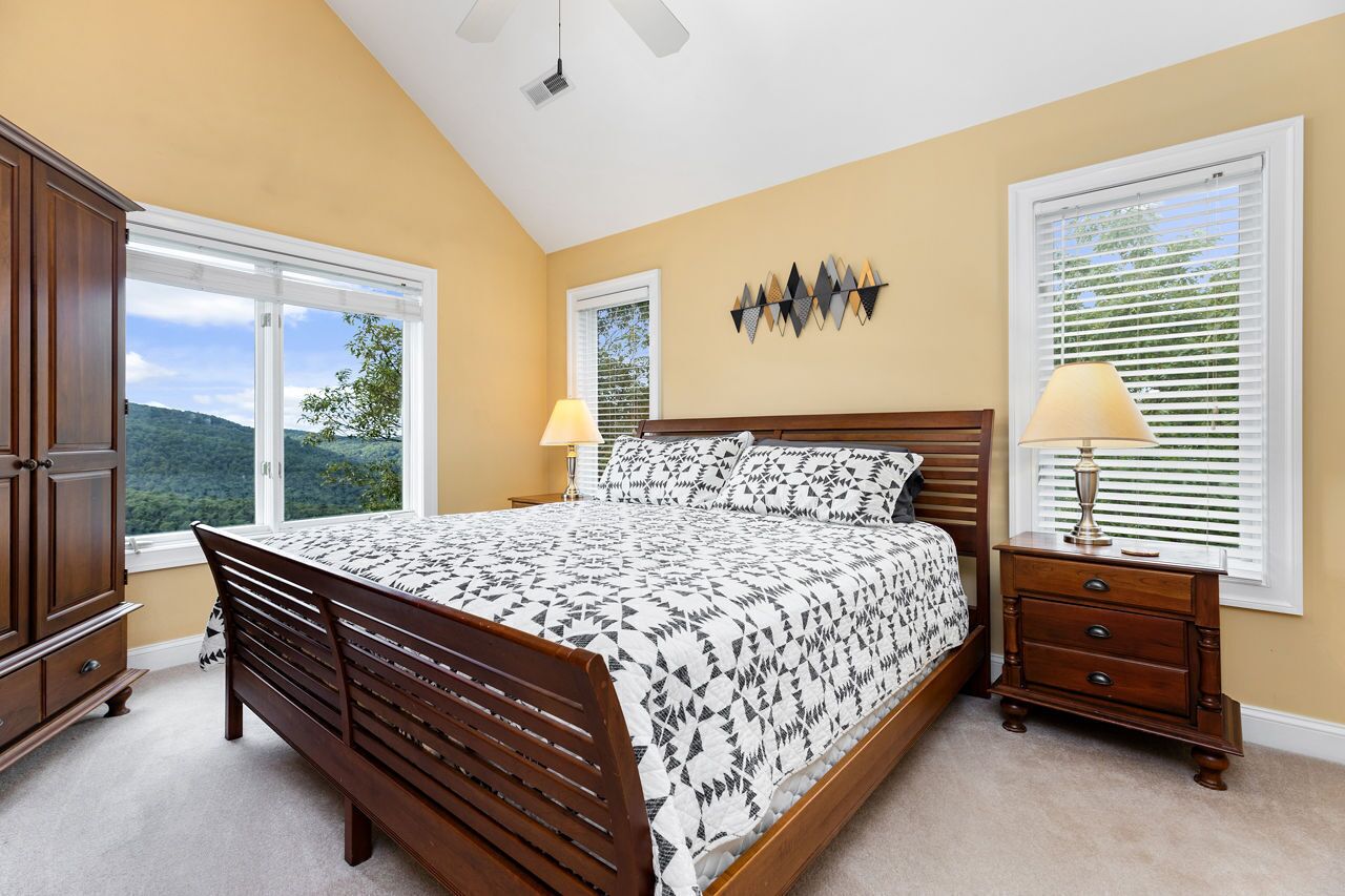 A bedroom with a large bed, two bedside tables, and a wardrobe.