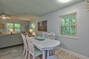 Enjoy meals in the dining area with a white table and comfortable seating.