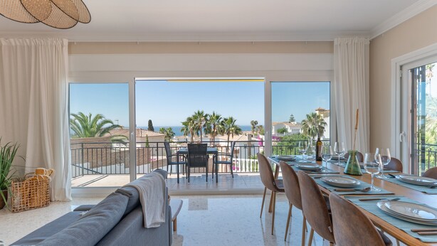 A dining area with a view of the sea, a balcony, and a sofa. - Villa 'Casa Leo Holiday' with Sea View, Wi-Fi and Air Conditioning (Mijas Costa)