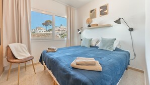 A bedroom with a bed, a chair, a window with a view, and a desk lamp. - Villa 'Casa Leo Holiday' with Sea View, Wi-Fi and Air Conditioning (Mijas Costa)