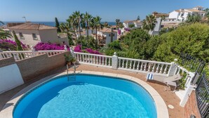 A swimming pool with a white balustrade, surrounded by greenery and overlooking a coastal town. - Villa 'Casa Leo Holiday' with Sea View, Wi-Fi and Air Conditioning (Mijas Costa)