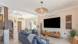 A modern living room with a sofa, coffee table, and TV. - Villa 'Casa Leo Holiday' with Sea View, Wi-Fi and Air Conditioning (Mijas Costa)