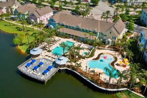 A resort with a large pool, a dock, and a variety of buildings.