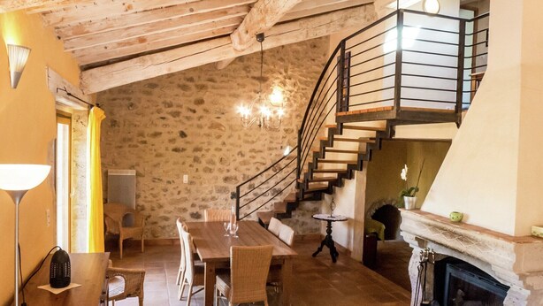 A rustic interior with a dining area, a fireplace, and a staircase. - Sunny Escape to Serenity (Fraissé-Des-Corbieres)