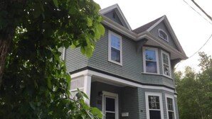 A two-story house with a gabled roof and a front porch. - A bright suite with lots of room for fun and relaxation, just 5 minutes from the Halifax ferry! (Dartmouth)