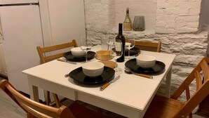 A dining table set with black plates, white bowls, and wine glasses, surrounded by wooden chairs. - A bright suite with lots of room for fun and relaxation, just 5 minutes from the Halifax ferry! (Dartmouth)
