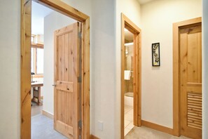 A hallway with wooden doors leading to a bathroom and a bedroom. - Summit Rose Escape • Theater Rm • Gourmet Kitchen (Frisco)