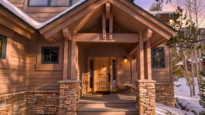 A wooden house with a stone foundation, a front porch, and a door. - Summit Rose Escape • Theater Rm • Gourmet Kitchen (Frisco)