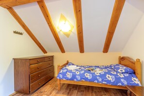 A bedroom with a wooden bed, a dresser, and a ceiling light fixture. - Chalet With Private Whirlpool And Sauna (Brod Moravice)