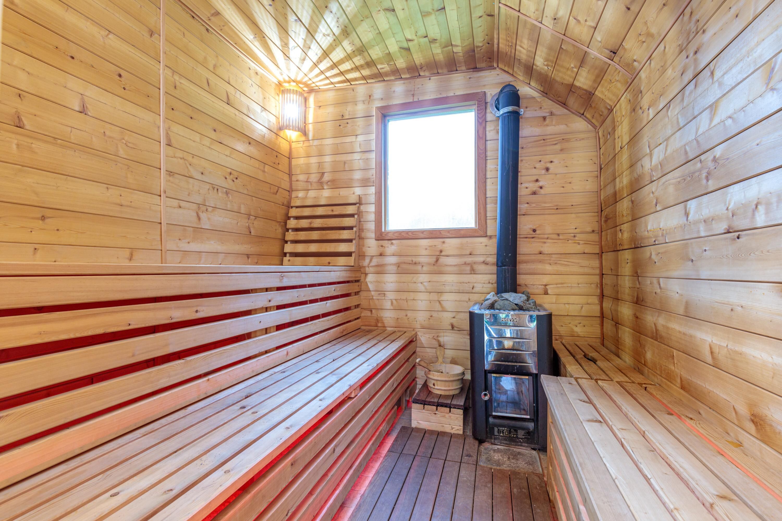 A sauna with wooden benches and a sauna heater.