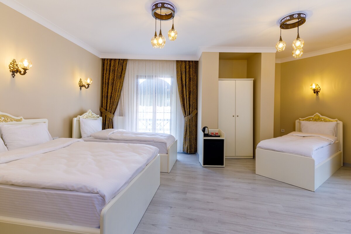Ein Hotelzimmer mit zwei Betten, einem Kleiderschrank und einem Schreibtisch.