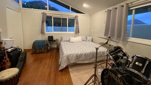 Une chambre avec un lit, une batterie et une guitare.