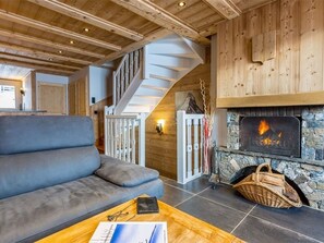 Una sala de estar acogedora con un sofá gris, una mesa de centro de madera y una chimenea.