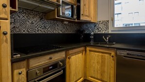 Une cuisine avec des meubles de rangement en bois, un four à micro-ondes, une cuisinière et un lave-vaisselle.