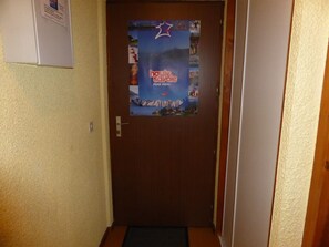 A hallway with a door featuring a poster advertising a ski resort. - 3-room apartment for 6 ppl, near slopes, parking (Combloux)