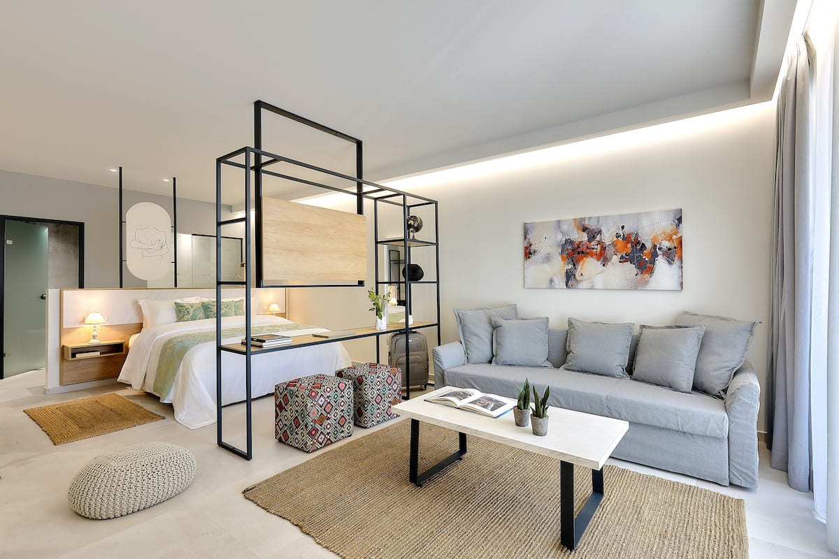 A modern, well-lit living room with a sofa, coffee table, and a bookshelf unit.
