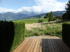 A wooden deck leading to a scenic view of a mountainous landscape with a clear sky. - Studio for 4, opposite ski lift, private terrace (Combloux)