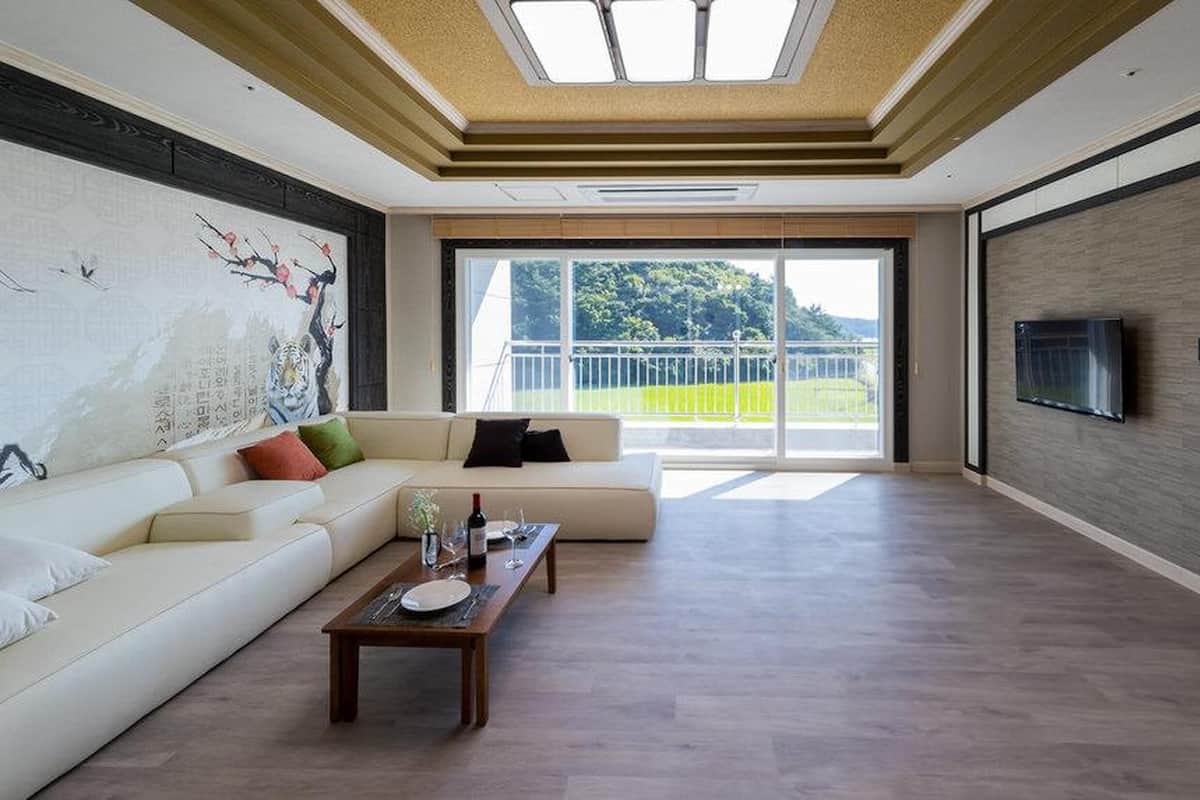 Un salon spacieux avec un grand canapé, une table basse et un tableau accroché au mur.