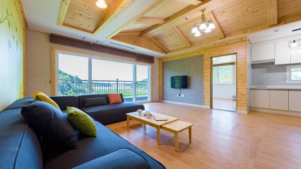 Amplia sala de estar con un sofá, una mesa de centro y un ventanal con vistas al exterior.