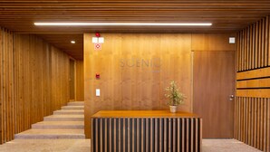 A reception area with a wooden reception desk, a staircase, and a wooden wall with the word "SCENIC" on it. - LUXURIOUS, BRIGHT & LARGE TERRACE WITH GREAT VIEW | Family-Friendly (Lisboa)