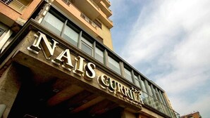 Um edifício com uma placa que diz 'NAIS CURRITZ'.