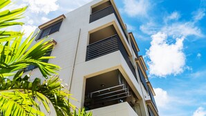 A multi-story building with balconies and a clear sky. - Lego (Uruma)