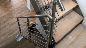 Eine moderne Treppe mit Metallgeländern und Holzbalken.