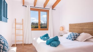 Een slaapkamer met een bed, een raam, een ladder en een stoel.