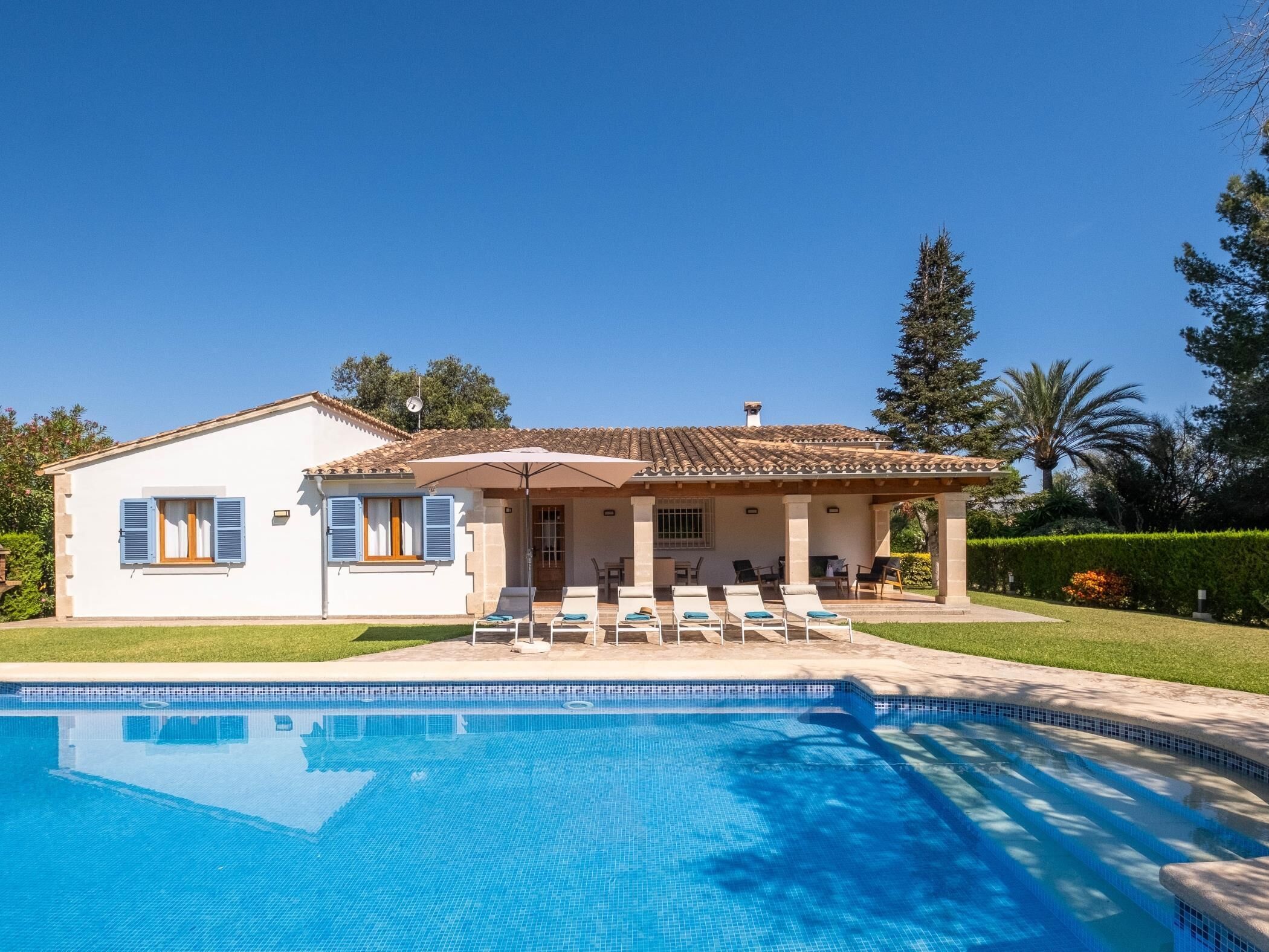 Une maison à deux étages avec une piscine à l’avant.