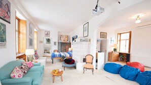 A cozy living room with a sofa, a chair, a bed, and a coffee table.