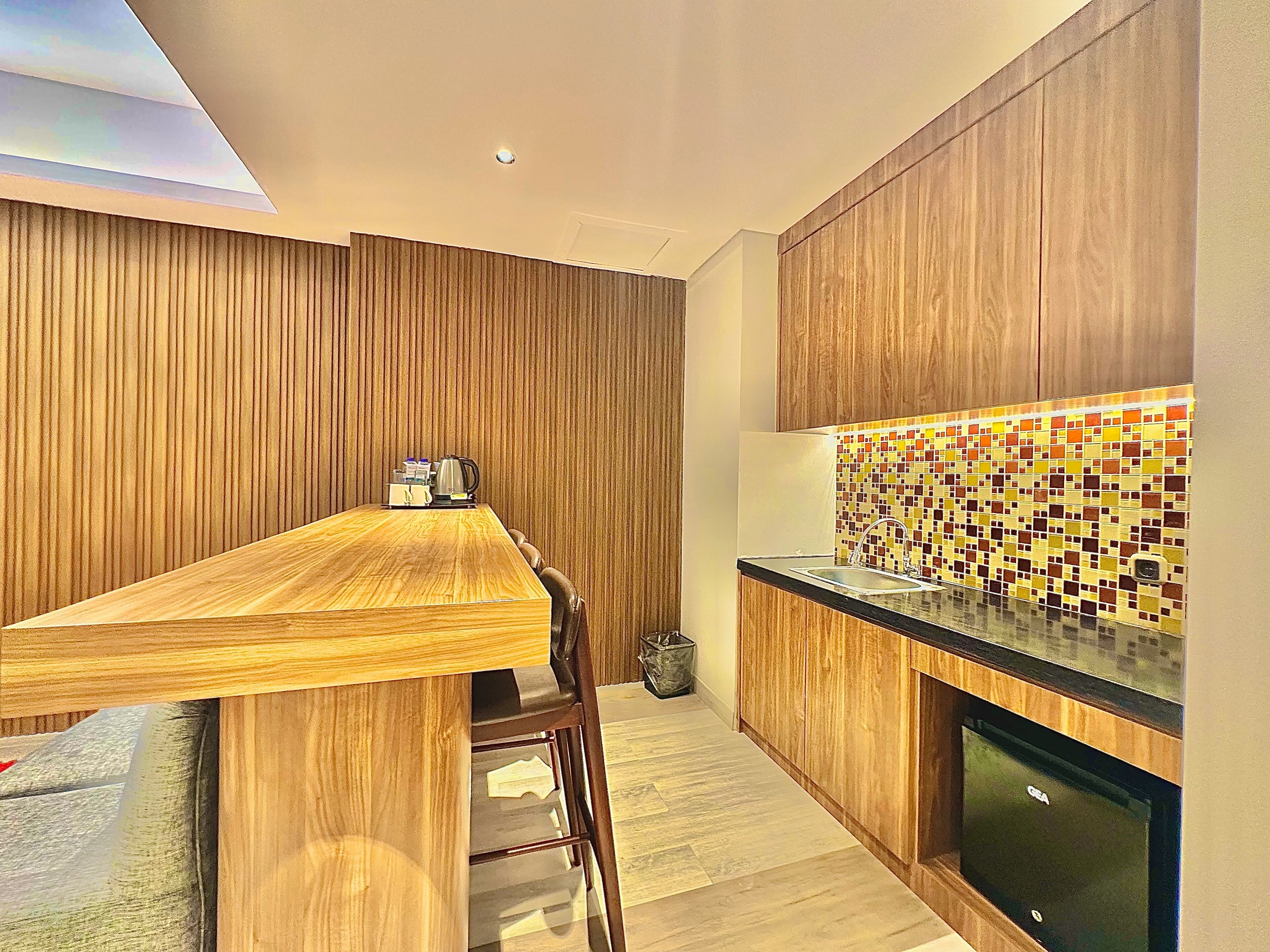 A modern kitchen with wooden cabinets, a tiled backsplash, and a wooden dining table.