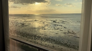 Een strand met uitzicht op zee en wolken.