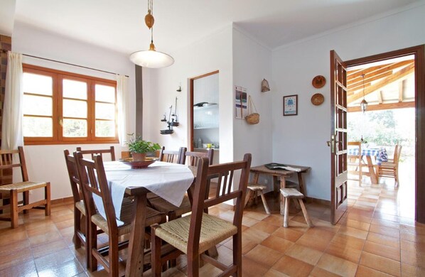 Un coin repas avec une table ronde, des chaises en bois et une plante en pot.