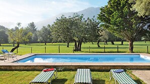 A swimming pool with three striped lounge chairs and a red towel. - Finca Can Pontico - Four Bedroom House, Sleeps 6 (Pollensa)