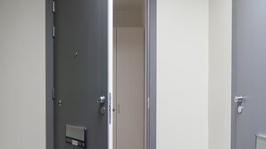 A room with a closed door, a visible light switch, and a textured floor. - 2ndhomes Ullanlinna Penthouse Apartments 2 (Helsinki)