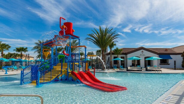 A water park with a slide, pool, and a bar/lounge area. - The Majorca at Windsor Westside (Kissimmee)