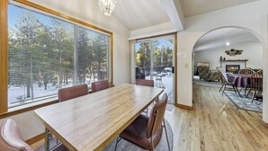 A dining area with a large table, chairs, and a view through the window. - Backs to National Forest!  Trails just outside your Door - Stunning!  1801J (South Lake Tahoe)