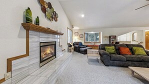A spacious living room with a fireplace, a sofa set, and a dining area. - Backs to National Forest!  Trails just outside your Door - Stunning!  1801J (South Lake Tahoe)
