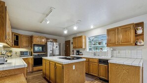 A spacious kitchen with wooden cabinets, a central island, and modern appliances. - Backs to National Forest!  Trails just outside your Door - Stunning!  1801J (South Lake Tahoe)