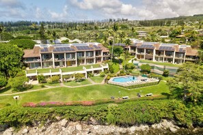 A resort with multiple buildings, a swimming pool, and lush greenery.