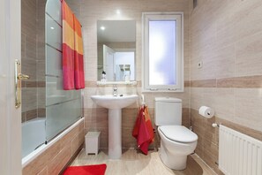 A bathroom with a glass shower enclosure, a pedestal sink, a toilet, and a window. - Apartment/ flat - Madrid (Madrid)