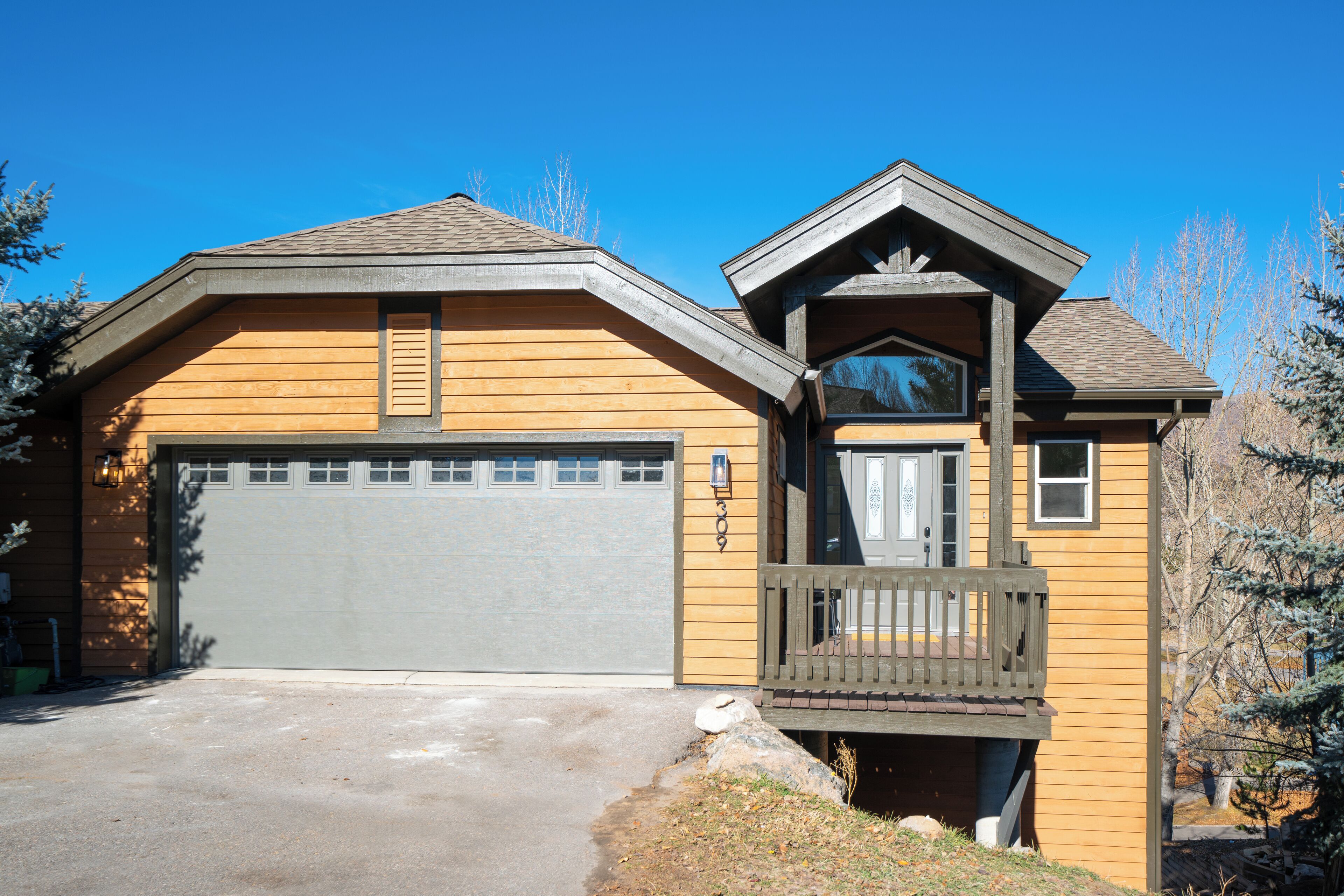 A two-story house with a garage, a balcony, and a small porch.
