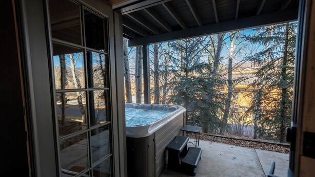 Un jacuzzi con vistas a árboles y un edificio al fondo.