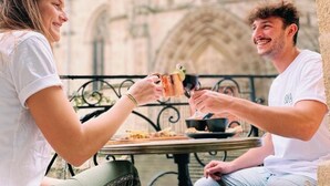Two people sitting at a table outdoors with a historic building in the background. - LOLA Boutique Hôtel Bordeaux Centre (Bordeaux)